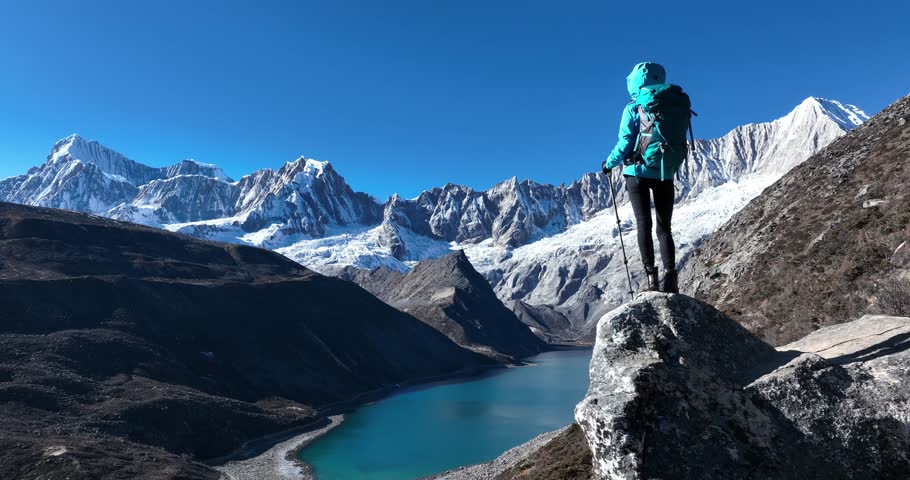 Backpacking woman hiking on high altitude mountain top