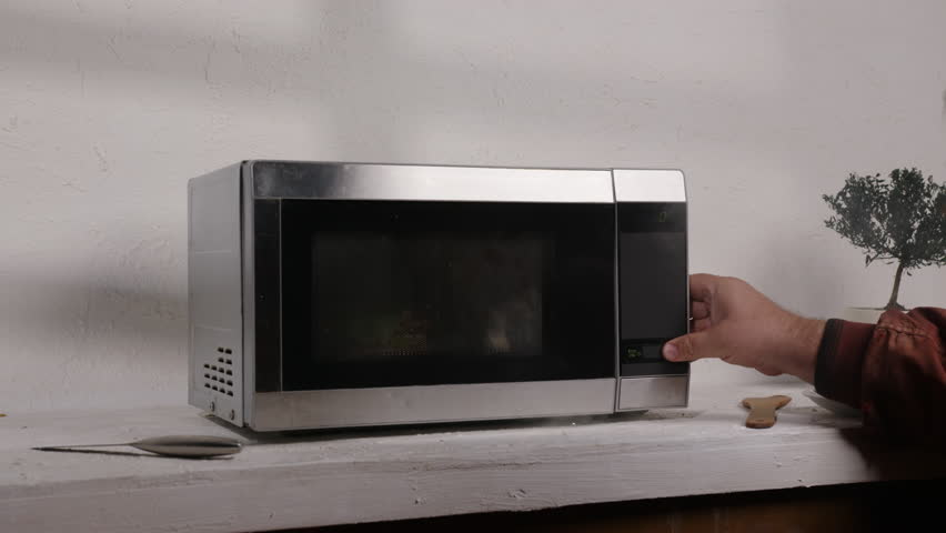 Microwave oven smokes and bursts into flames after turning on electricity, starting house fire.