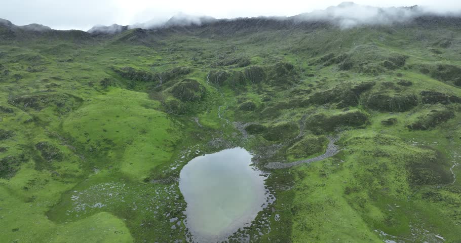 Aerial footage of beautiful high altitude grassland and mountain landscape