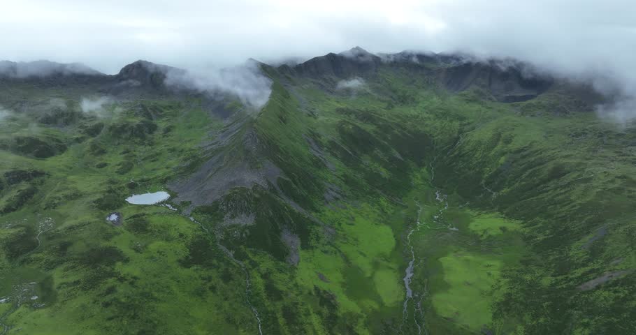 Aerial footage of beautiful high altitude grassland and mountain landscape