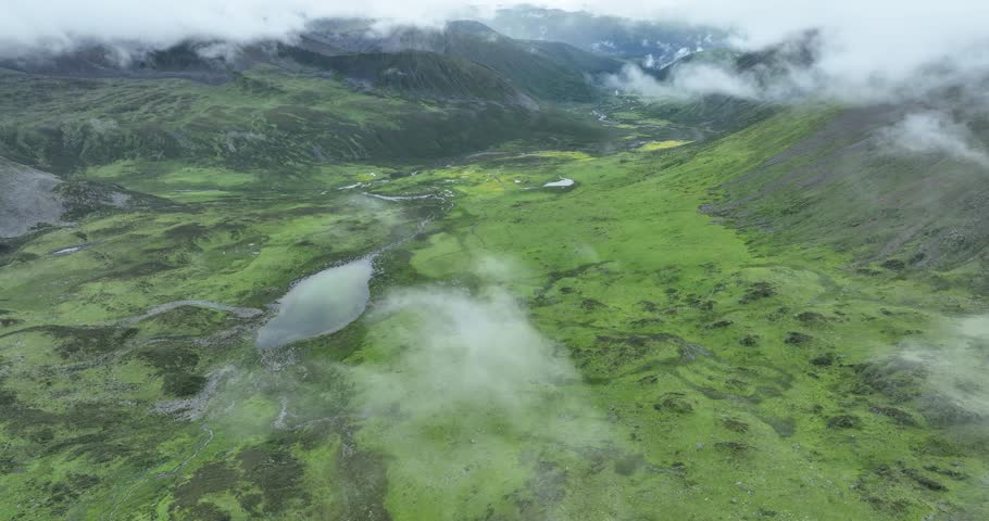 Aerial footage of beautiful high altitude grassland and mountain landscape