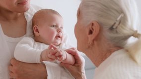 Mother, grandmother and little baby child on hands indoors. - Powered by Shutterstock - Get 15% off with code: PIKWIZARD15