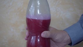 bubbles Air coming out of a bottle of sweet soda, a plastic bottle with red sparkling water close-up, air bubbles and foam in the middle of the bottle - Powered by Shutterstock - Get 15% off with code: PIKWIZARD15