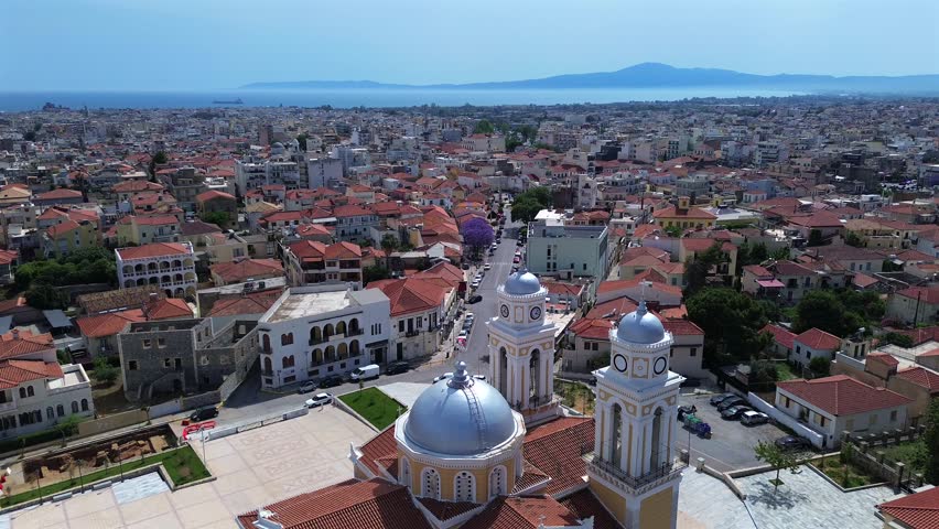 Aerial high view of Kalamata cityscape, orbital drone movement with famous metropolitan cathedral, Ypapanti church in the foreground. Panoramic view of the city, with Messinian bay on background