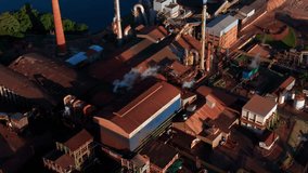 Drone aerial landscape of ethanol production plant warehouse facility factory buildings with steam turbines in countryside rural town by lake and crops Brazil South America industry refinery - Powered by Shutterstock - Get 15% off with code: PIKWIZARD15