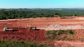 Drone aerial landscape of dump truck reversing carrying soil to excavator digger machinery equipment at landfill tip site dirt mound in Brazil South America industry waste disposal operation - Powered by Shutterstock - Get 15% off with code: PIKWIZARD15