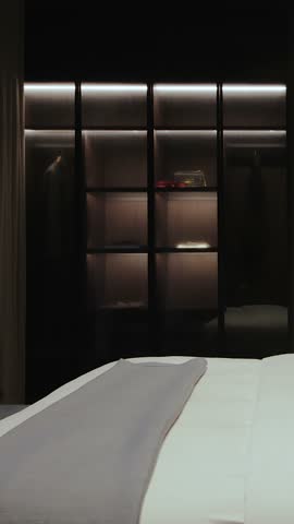  Vertical screen: a black wardrobe in a modern bedroom with a cozy design and lighting.Luxury Modern Apartment Interior
