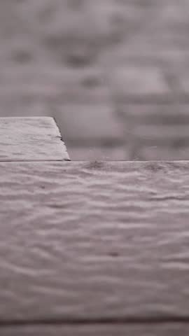 Heavy rain, a shower, large heavy drops drip onto the street tiles. rain drop on wet floor texture, Heavy rain drops on asphalt. puddles of water during heavy rain