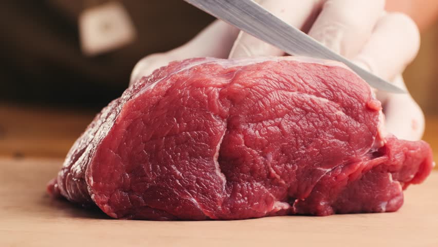 Man cut meat steak, beef pork neck cooking, Cook Butcher. The chef cuts the meat for cooking. Neck carbonate with vegetables cutting on ktchen for bbq grill, marinade. 