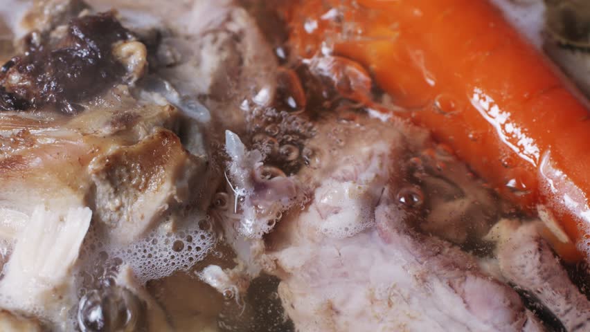 Cooking pot with bone broth meat pork and beef, aspic north food. Vegetables cooking ingredients and spices on kitchen table. 