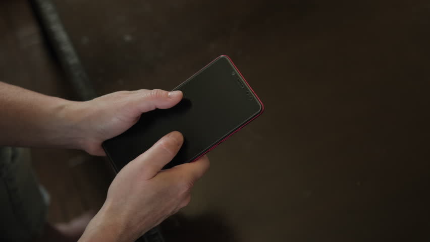 Overheated smartphone smokes in human hands of user close-up