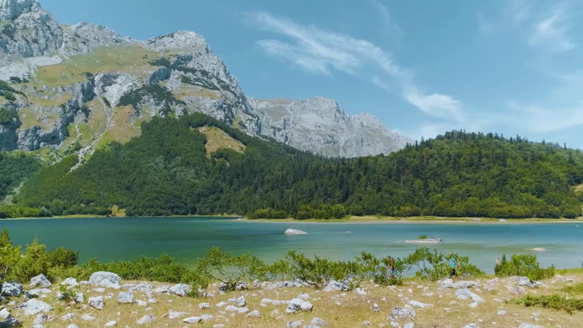 Serene Mountain Lake Landscape with Boats and Lush Greenery