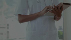 Doctor tapping tablet screen in clinic and reviewing genetic data with animated DNA helix floating. Medical, technology, science, innovation, healthcare, analysis, research - Powered by Shutterstock - Get 15% off with code: PIKWIZARD15