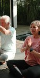 Vertical video: Meditating outdoors, senior couple having peaceful yoga session together in park. meditation, wellness, relaxation, mindfulness, tranquility, exercise - Powered by Shutterstock - Get 15% off with code: PIKWIZARD15