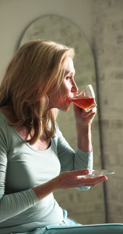 Vertical video: Smiling senior woman enjoying festive season at home, feeling joyful and relaxed. Elderly, holiday, celebration, happiness, cheerful, cozy