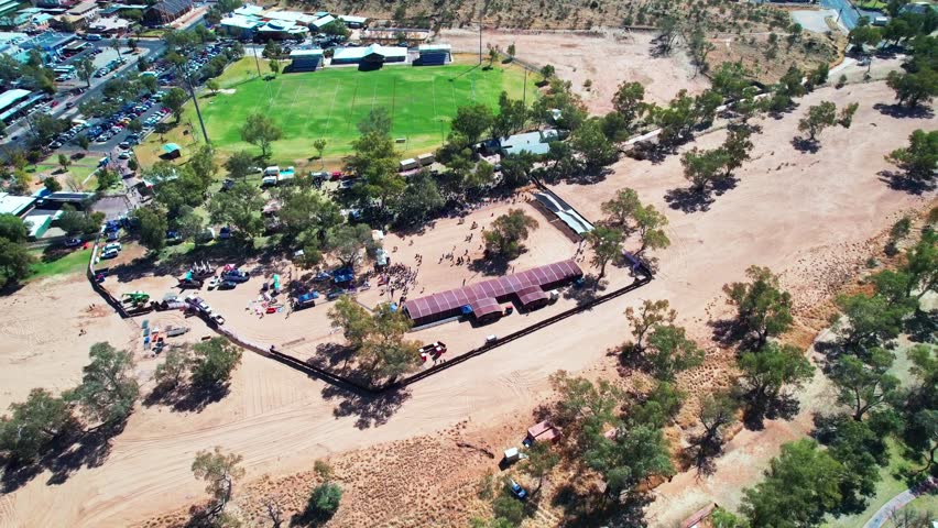 Circling aerial footage of Henly on Todd Regatta on the dry river bed of the Todd River, Alice Springs, Mparntwe. Northern Territory, Australia. August 2022.