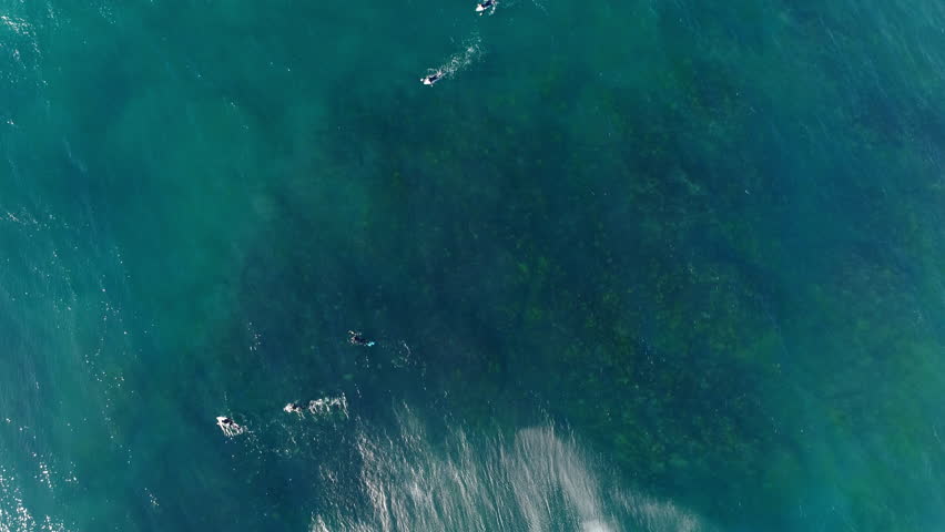 Abstract aerial of shifting ocean colors as lineup drifts in open water beyond reef and break zone