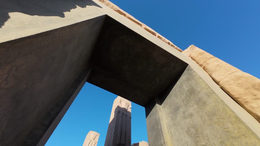 Ancient stone gate at Karnak Temple viewed from below in warm afternoon light