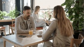 Friendly couple sharing warm conversation over refreshing beverages, enjoying casual interaction in modern urban cafe with natural light streaming through window - Powered by Shutterstock - Get 15% off with code: PIKWIZARD15