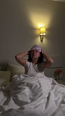 Relaxed evening routine, woman prepares for sleep and puts on sleep mask in bed