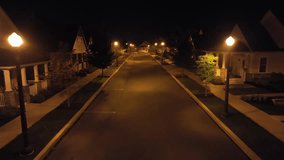 Empty street of modern american housing area with orange lighting lantern at night. POV dolly forward shot. Sidewalk and green trees at nighfall in american Suburb Town.New single family houses in USA - Powered by Shutterstock - Get 15% off with code: PIKWIZARD15