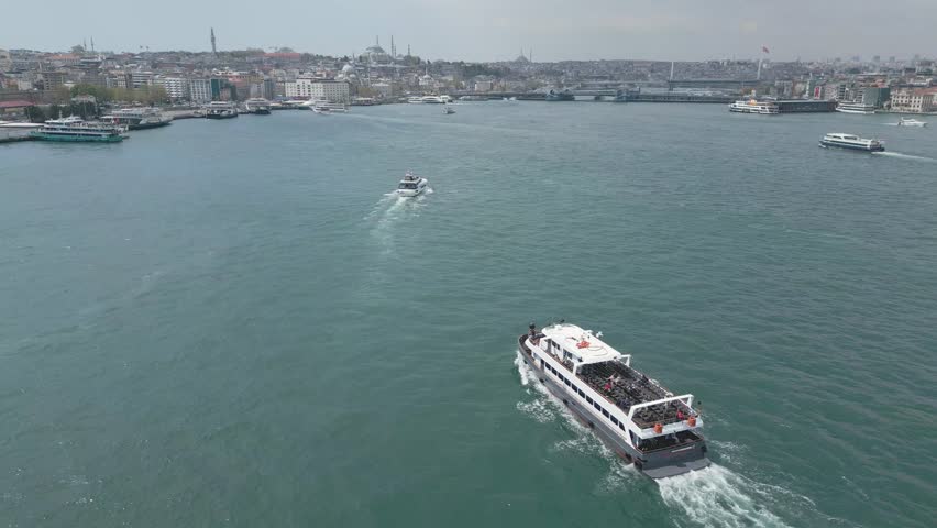 The vibrant waters of Istanbul showcase boats navigating the scenic landscape. The skyline features historic buildings, creating a captivating view of this bustling city on a sunny day.