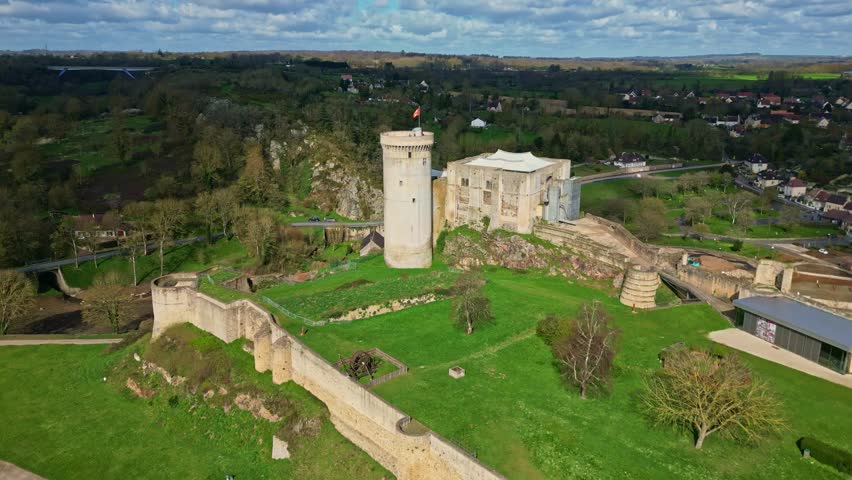 Historic Château de Falaise, birthplace of William the Conqueror, surrounded by lush trees, Normandy, France, Medieval landmark. Aerial forward