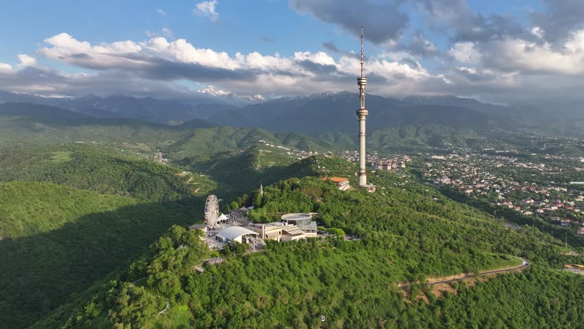 Mount Kok Tobe (Blue Hill) with the famous TV tower against the backdrop of the Zailiyskiy Alatau mountain range in the Kazakh city of Almaty on an  spring evening