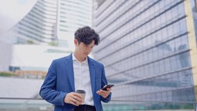 Asian young businessman chatting on smartphone while standing in city. Attractive handsome male employee worker communicate and discuss on mobile cellphone with colleagues outdoors with confidence. - Powered by Shutterstock - Get 15% off with code: PIKWIZARD15