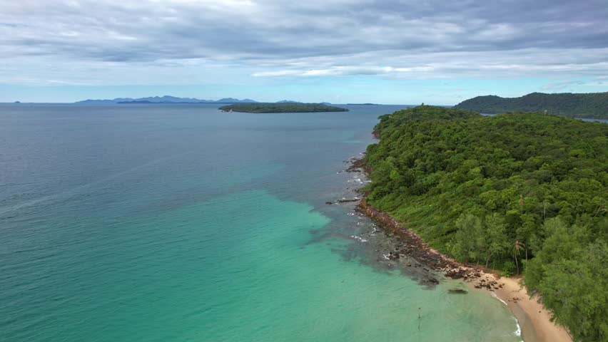 Aerial drone shot above the Andaman Sea paradise island. Drone POV capture turquoise water and tropical landscape showing beauty of summer vacation in serene holiday destination of Koh Kood, Thailand.