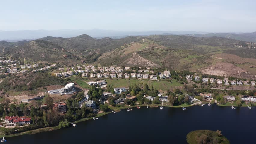 Aerial high panning shot of a luxurious residential neighborhood along Lake Sherwood in Southern California. 4K at 30 FPS