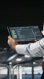 Vertical video Close up of data center programmer looking at code debugging tools running on tablet. Server farm IT professional checking machine learning script automating tasks, camera A - Powered by Shutterstock - Get 15% off with code: PIKWIZARD15