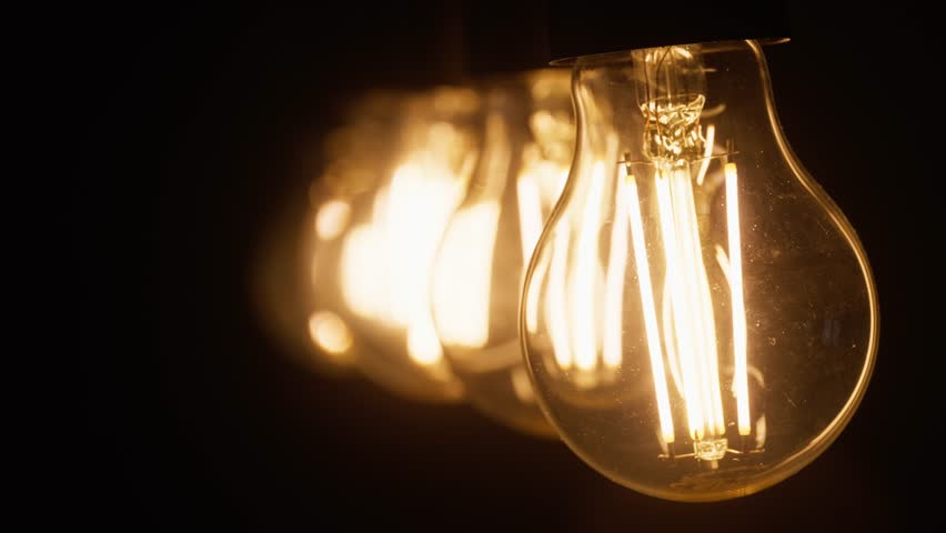 Light bulbs that glow in the dark sway from side to side. Light in the dark.
