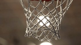 Close-up of a basketball swishing perfectly through an orange hoop and white net. Dynamic sports action shot isolated on a stark black background, highlighting success. - Powered by Shutterstock - Get 15% off with code: PIKWIZARD15