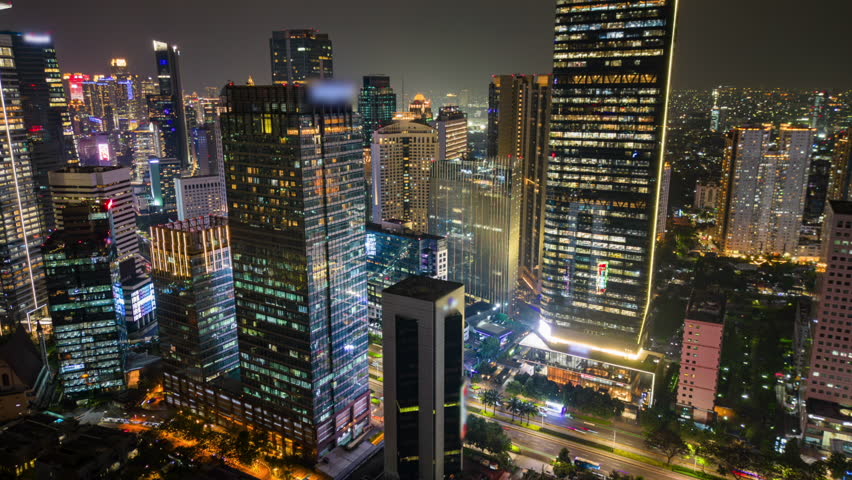 Aerial timelapse of Jakarta business district at night with busy traffic, illuminated skyscrapers, and city skyline. Ideal for city, business, travel, and infrastructure themes.