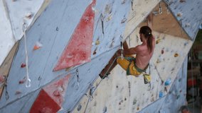 athletic male climber without t-shirt climb tough route on artificial climbing wall at outdoor city gym. practicing, sport training, concentration. rock climbing session in urban life. slow motion. - Powered by Shutterstock - Get 15% off with code: PIKWIZARD15