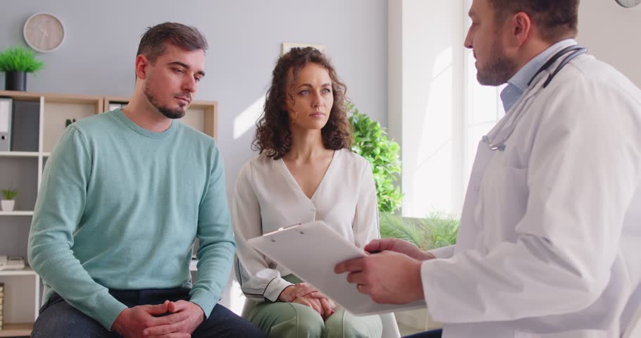 Young couple at reception with family therapist, doctor explaining health problems, family relationship married spouse consulting with male psychologist at therapy session, relationships problems