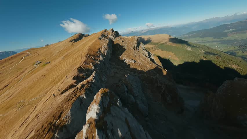 Smooth flight along the mountain range, filmed by FPV drone. Seceda, Italy