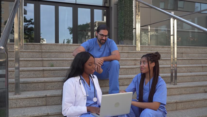 Video of Medical team discussing patient data on laptop sitting on steps outdoors - Powered by Shutterstock - Get 15% off with code: PIKWIZARD15