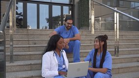 Video of Medical team discussing patient data on laptop sitting on steps outdoors - Powered by Shutterstock - Get 15% off with code: PIKWIZARD15