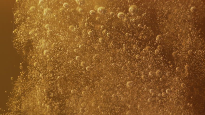 Slow motion macro shot beer pouring into a glass. Beautiful Beer Bubbles Rising Up. Loopable Animation of Sparkling Water. Video 4K