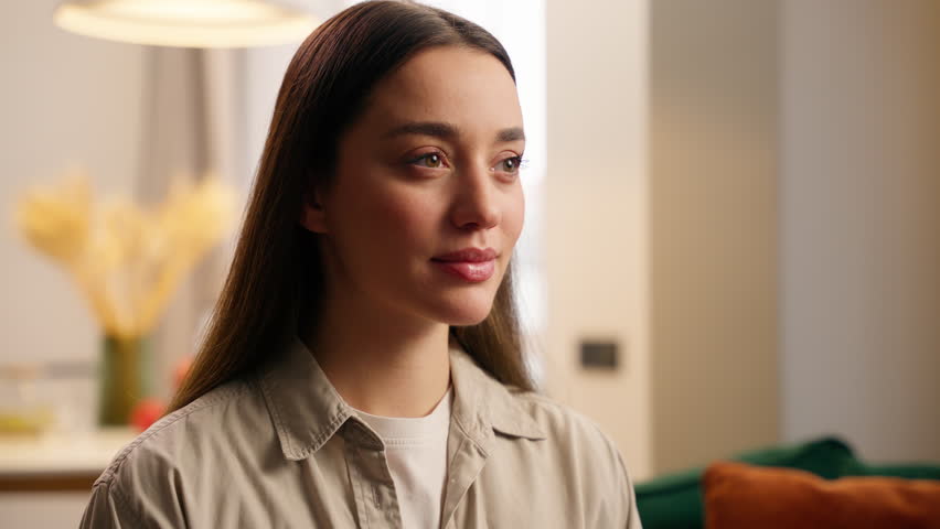 Close up Caucasian woman female smiling toothy white teeth satisfied carefree relaxing in apartment cozy interior living room looking at camera. Portrait at home pretty smile young girl good mood