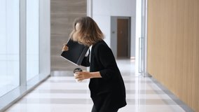 Happy businesswoman dancing in office corridor while holding tablet and coffee, enjoying work, celebrating success, or simply having fun during break - Powered by Shutterstock - Get 15% off with code: PIKWIZARD15