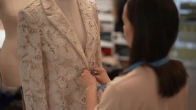 Back view of fashion designer taking measurements of white lace blazer draped on mannequin, ensuring perfect fit and crafting high-quality garment in atelier. Concept of garment manufacturing. - Powered by Shutterstock - Get 15% off with code: PIKWIZARD15