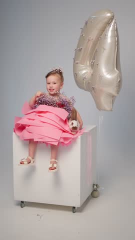 Smiling little girl in a pink dress. Children