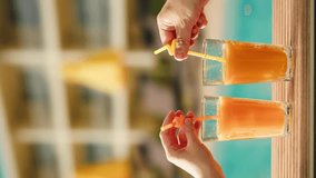 Fruit cocktail in hotel bar, Two cocktail glasses cheers in the hands on sea background. Bartenter making drink in bar, Summer vacation concept, A beautiful couple enjoy the vacation at the beach. - Powered by Shutterstock - Get 15% off with code: PIKWIZARD15