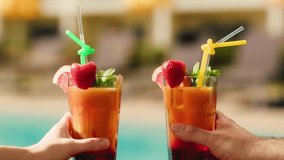 Fruit cocktail in hotel bar, Two cocktail glasses cheers in the hands on sea background. Bartenter making drink in bar, Summer vacation concept, A beautiful couple enjoy the vacation at the beach. - Powered by Shutterstock - Get 15% off with code: PIKWIZARD15