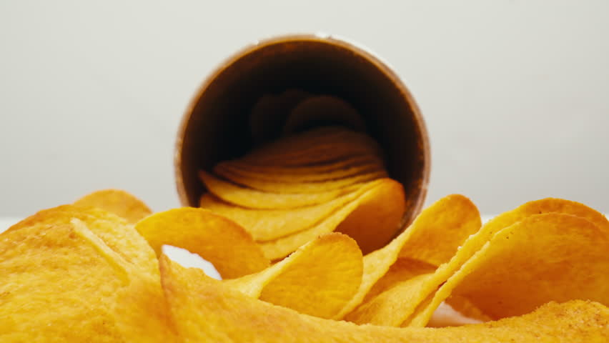 Crispy potato chips close up pack in macro. Golden fried potatoes close up. Potato snack for unhealthy fast food. 