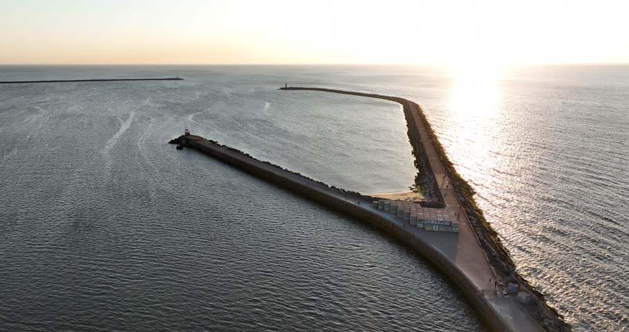 pier at Ijmuiden, small lighthouse beacon at the entrance of the North sea canal, Ijmuiden, The Netherlands, sea scape, sunset golden hour aerial view.