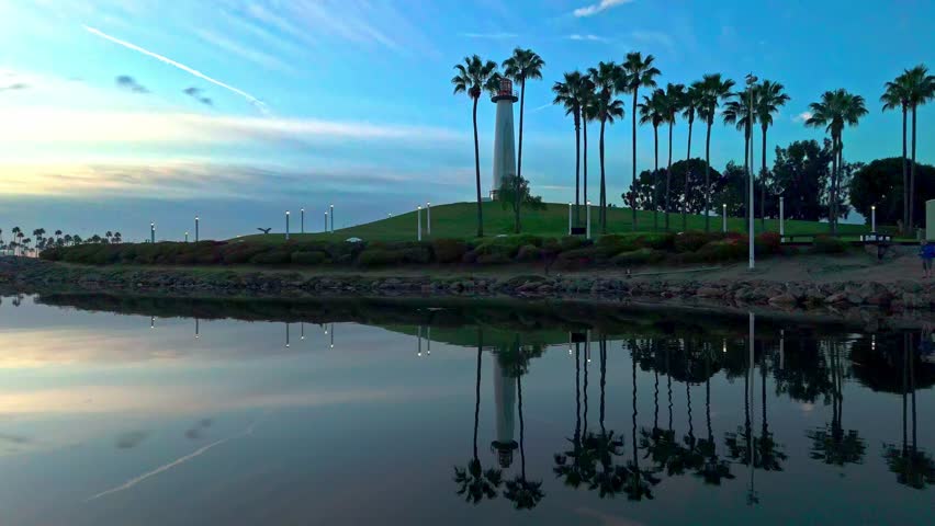 Aerial view of Lions Lighthouse at sunrise, revealing calm waters and distant ships in Long Beach, California.